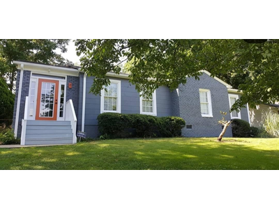 A house painted blue with white trim and red accents