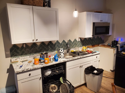 a kitchen counter with mosaic backsplash tiles beginning to be laid
