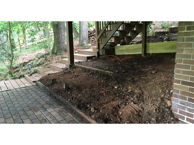 Uncared for under-stairs area, a rough dirt slope