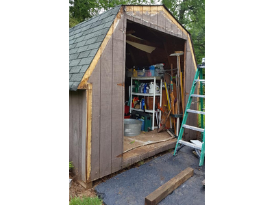 A weather-beaten shed with no door and missing trim